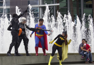 Nightwing and Deathstroke are threatening Batgirl, while Superman tries to protect her, while a child and father watch the "action" out in front of the Anaheim Convention Center at Wondercon 2014.