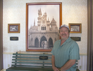 Scott Zone, the official archivist of the Disney family home movies, stands in front of a bench from Griffith Park at Disneyland.